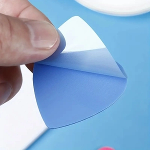 Gros plan montrant le dos adhésif blanc d'un pense-bête bleu en forme de cœur