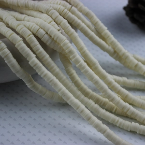 Close-up of 4mm and 6mm off-white polymer clay spacer beads for DIY jewelry making