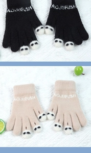 Close-up of knitted gloves in black and beige featuring cute paw prints and embroidery