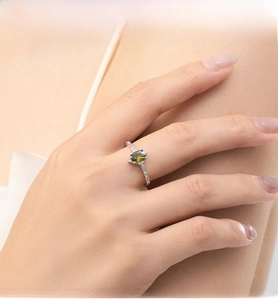 Detail of s925 silver ring featuring an olive green marquise gemstone on a hand