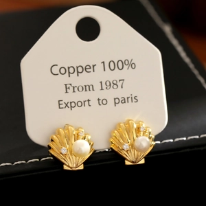 Elegant gold shell stud earrings with white pearl and cubic zirconia in a jewelry box