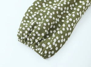 Détail du poignet élastique sur une robe olive à pois avec un tissu léger et doux