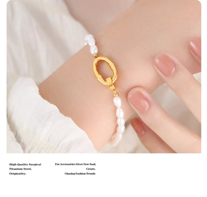 Detail view of a freshwater pearl bracelet with a golden titanium steel oval clasp on a wrist