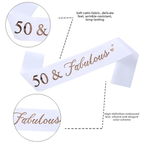 Close-up of white satin birthday sash with 50 & Fabulous rose gold metallic lettering