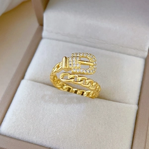Macro shot of gold chain ring featuring a crystal-encrusted belt buckle on velvet