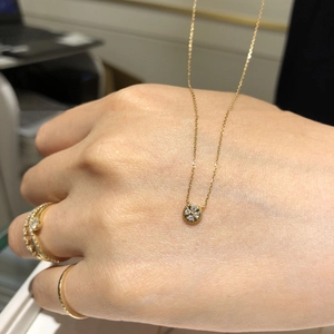 14K gold plated S925 silver necklace with round cubic zirconia pendant on model's hand