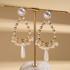 Close-up of vintage baroque style teardrop pearl earrings with gold woven frames
