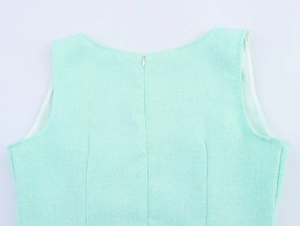 Detail of the mint green textured fabric and back zipper closure on the sleeveless dress