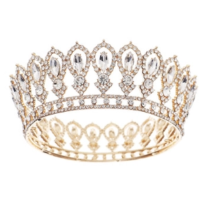 Close-up of golden vintage crown featuring intricate crystal rhinestones on a white background