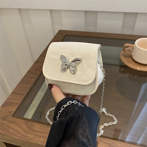 White mini crossbody bag with silver butterfly buckle and chain strap for women