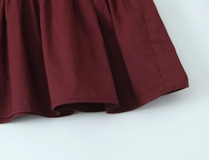 Détail de l'ourlet de chemise bordeaux à texture nid d'abeille avec coutures précises