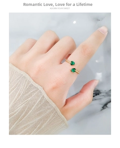 Close-up of dual green heart-shaped zircon stones on a gold-plated adjustable ring