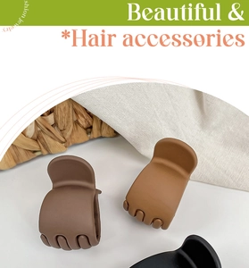 Set of large matte hair claws in dark brown, khaki, and black on a woven basket