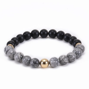 Close-up of matte black beads with white marble stone and a gold-tone accent bead