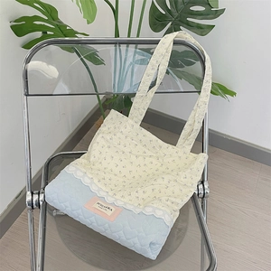 Detail of floral pattern and blue quilted fabric with lace on tote shoulder bag