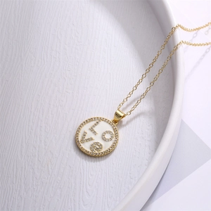 Detailed macro view of gold necklace with zircon LOVE heart pendant on white plate
