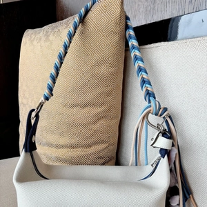 Handwoven blue and beige rope strap on canvas crossbody bag with decorative tassels