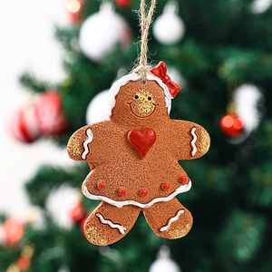Close-up of a gingerbread girl resin ornament with a red bow on a green Christmas tree