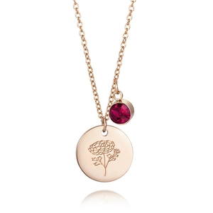 Detail of rose gold necklace with carnation flower engraving and red zircon stone