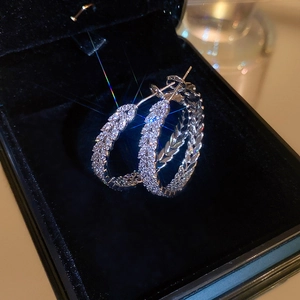 Elegant silver circle earrings with zircons and leaf carvings on a luxury velvet box