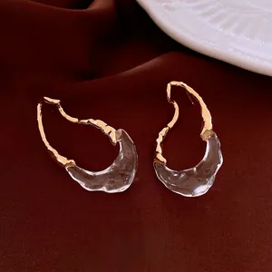 Orecchini a goccia irregolari placcati oro 18k con texture ondulata su sfondo velluto