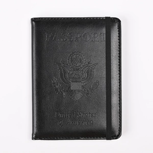 Detalle de funda para pasaporte en cuero negro con sello de EE. UU. y banda elástica