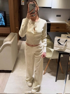 Detail of cream knit cardigan and high-waist wide-leg pants set showing soft texture