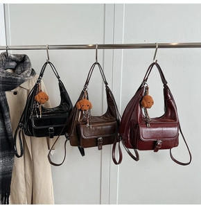 Detailed display of three classic color shoulder bags with plush puppy pendants