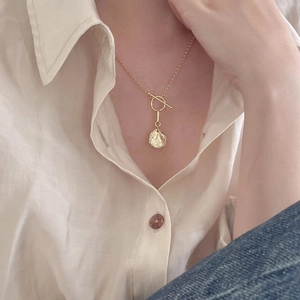 Close-up of minimalist gold 925 silver irregular pendant necklace with toggle clasp on model