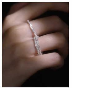 Close-up of S925 sterling silver knot ring with sparkling crystals on a hand