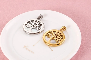 Macro view of gold and silver Tree of Life circular pendants on a white ceramic plate