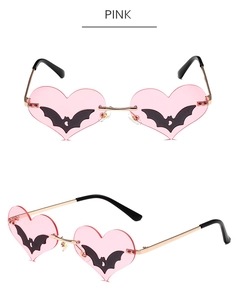 Detailed view of pink heart-shaped bat sunglasses with golden metal frames and black tips