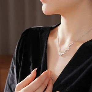 Vue rapprochée d'un collier papillon en argent avec zircons et nacre porté par un mannequin