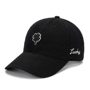 Detail of four-leaf clover and Lucky embroidery on black cotton baseball cap fabric