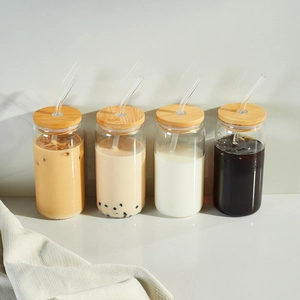 Clear glass can cups set with natural bamboo lids and reusable straws for cold drinks