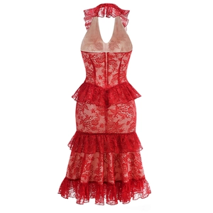 Detailed view of intricate red lace fabric and multi-layered ruffled hemline on a dress
