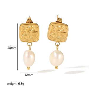 Detail view of square hammered gold steel earrings with baroque freshwater pearl drop