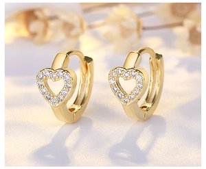 Macro detail of gold heart hoop earrings with micro-paved white zircons and hollow design