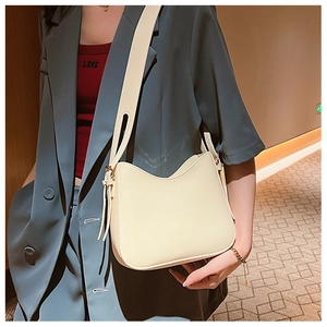 Sac sous le bras chic en cuir PU blanc crème porté par un mannequin dans un hôtel