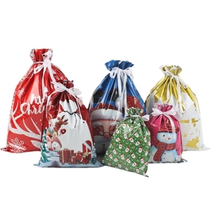 Variety of festive Christmas drawstring gift bags with colorful holiday prints and patterns