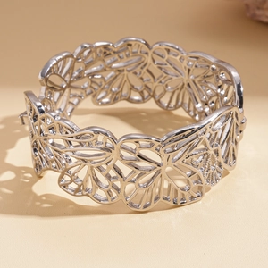 Détail d'un bracelet ajouré argenté avec motifs de fleurs et fermoir en métal poli