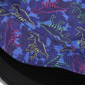 Dettaglio del motivo dinosauro e stampa mimetica sul cappello a secchiello reversibile