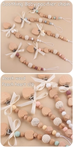 Detail of baby pacifier clips featuring beech wood beads and handmade crochet bows