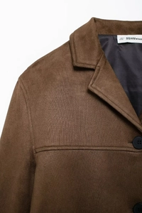 Detailed macro view of the brown suede jacket texture and black buttons on lapel