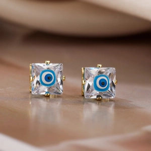 Close-up of gold evil eye stud earrings with square cubic zirconia and blue enamel detail