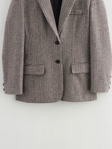 Detail of red and black houndstooth blazer showing fabric texture and buttons