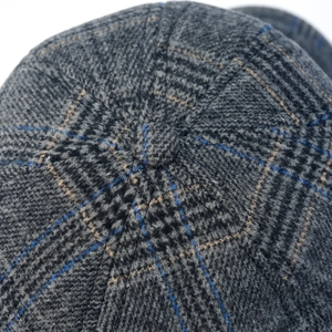 Macro shot of gray plaid wool fabric texture with top button on the baseball cap