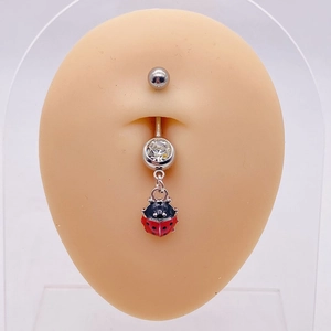 Close-up of stainless steel belly ring with red ladybug pendant on navel model