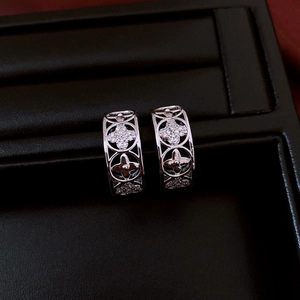 Detailed view of silver C-shaped floral hoop earrings with sparkling pavé crystals