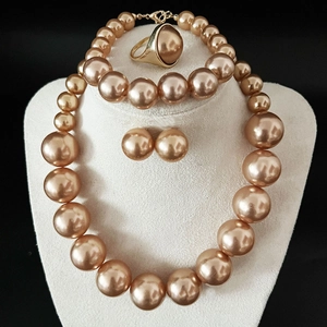 Elegant 4-piece set with golden pearls and metal jewelry on a professional model